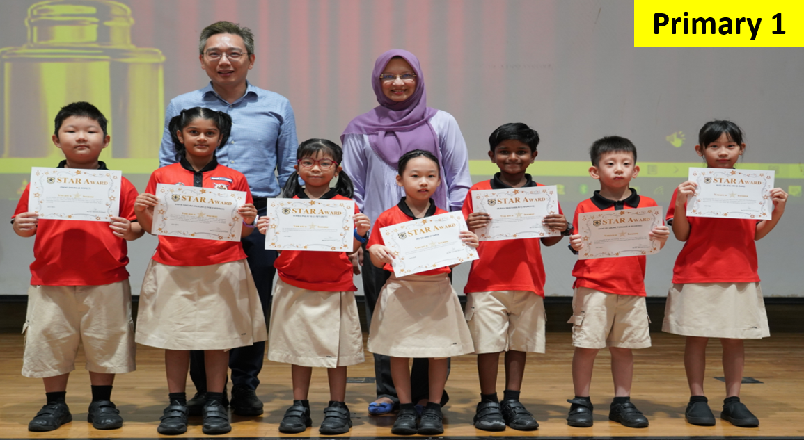 Six young students in red uniforms hold Star Award certificates, flanked by two adult teachers on a stage.